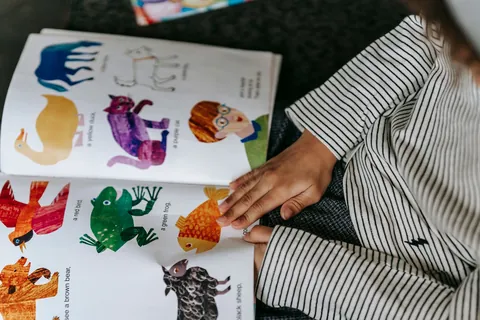 A young child reading a colorful illustrated picture book