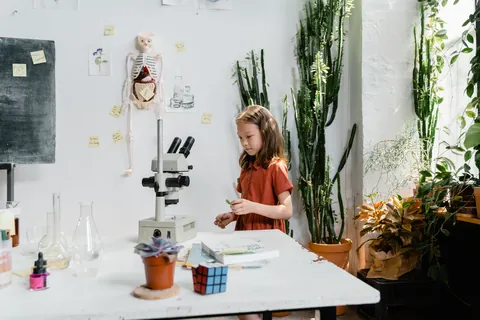 A child examining samples at a science workbench surrounded by lab equipment and plants