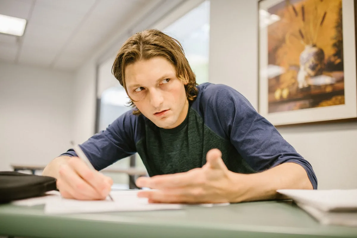 A nervous student looking down at a desk during an exam