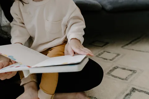 A person holding an open book while reading quietly