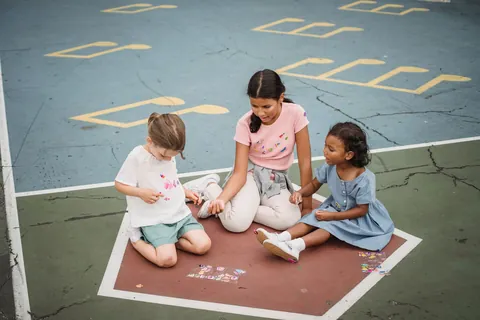 Young children playing together on a playground mat during recess